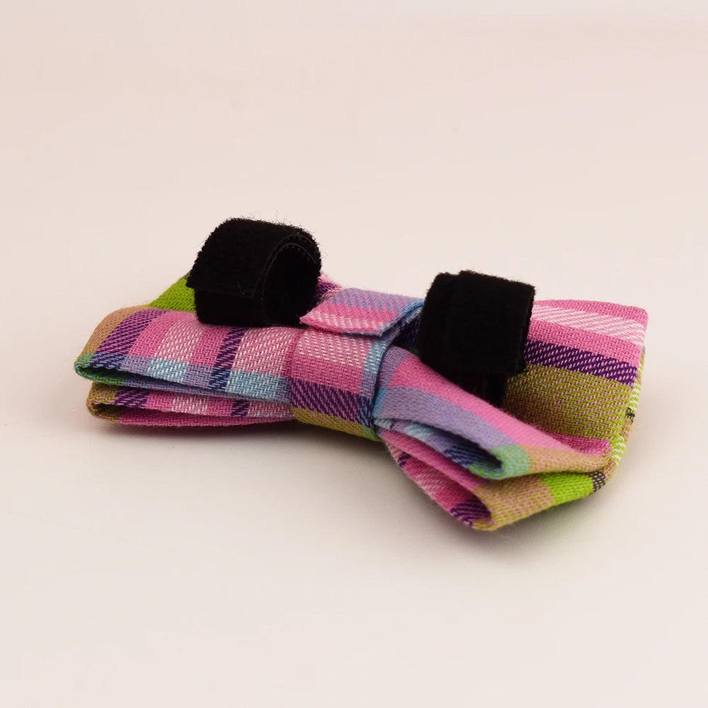 Colorful plaid bow tie with black accents on a light beige background