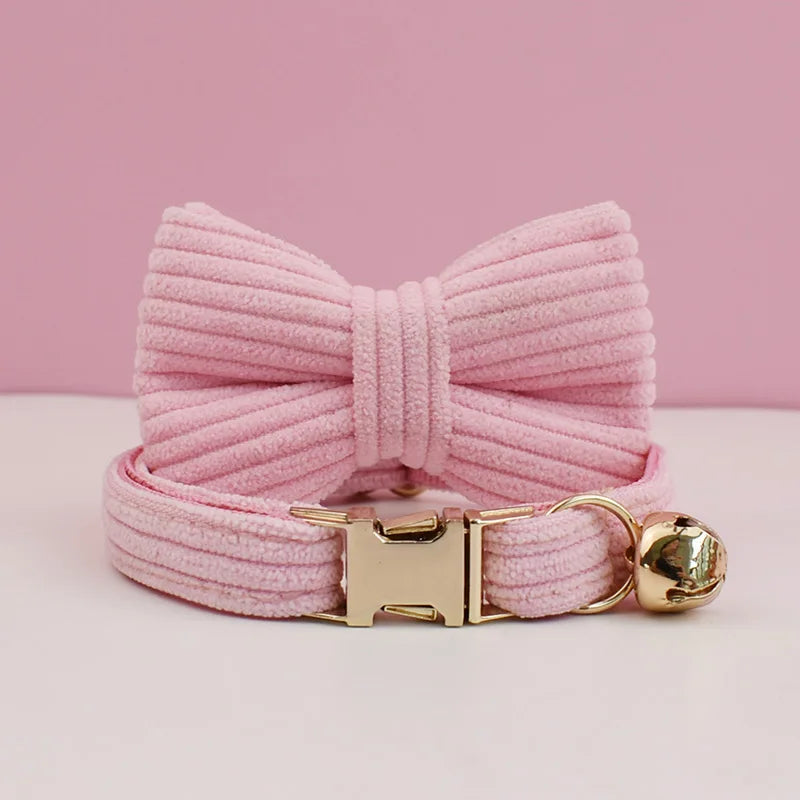 Pink dog collar with a large bow and gold buckle on a pink background