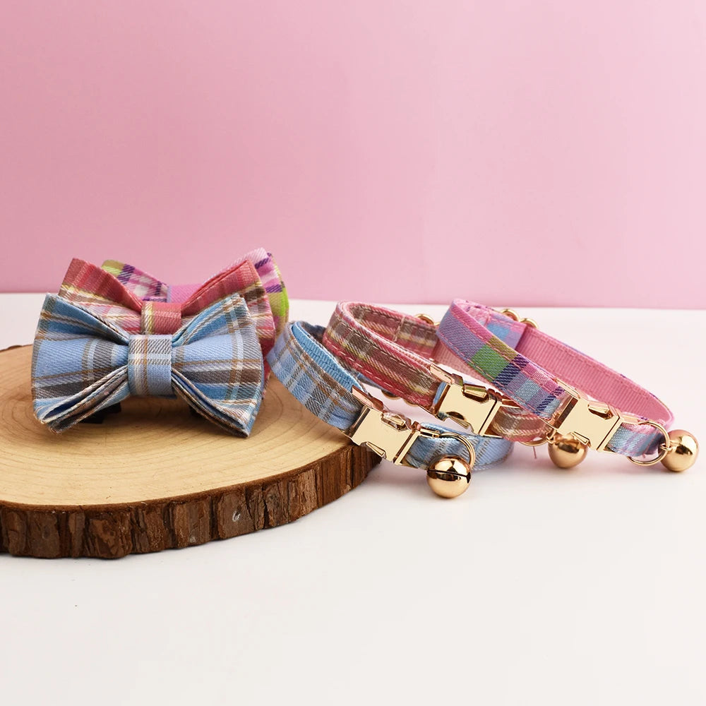 Plaid dog collars with bow ties on a wooden block against a pink background
