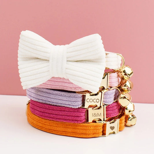 Stack of colorful hair ties with a large white bow on a pink background