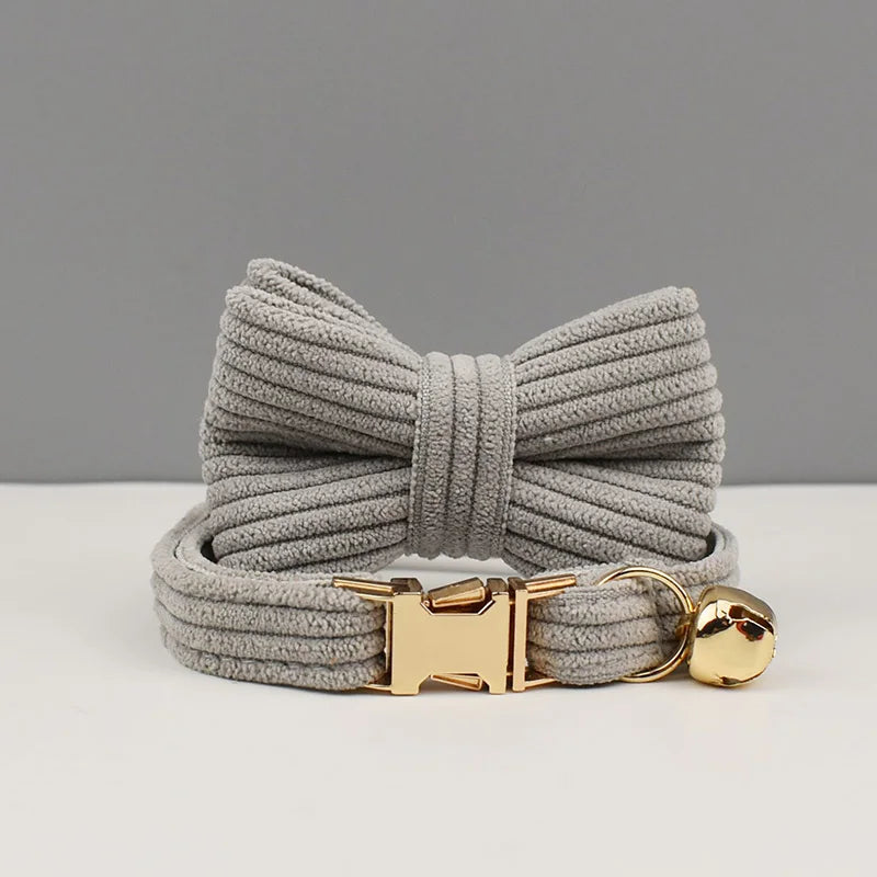 Gray dog leash with gold clasp and bell on a light gray background