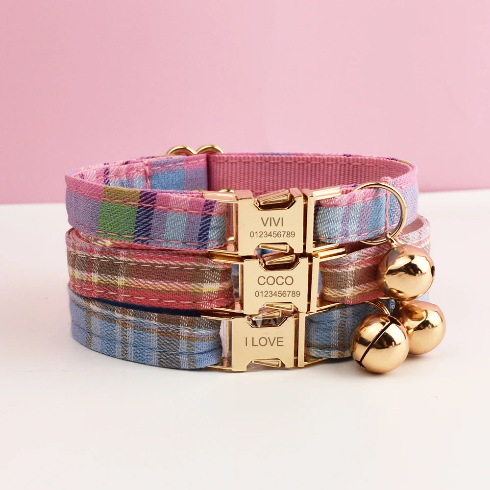 Stack of plaid dog collars with gold buckles and bells on a white surface with pink background